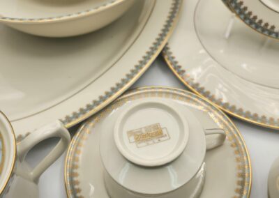 Elegant porcelain dinnerware set with gold and black trim.
