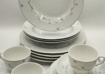 Elegant white porcelain tea set with floral design and silver trim.