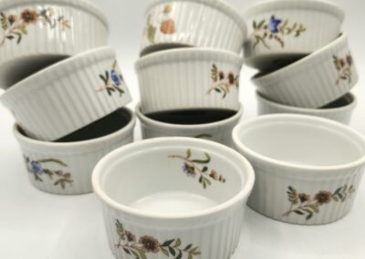 White ceramic ramekins decorated with colorful floral designs.