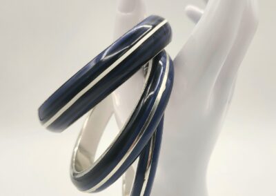 Elegant black and silver spiral bracelet on a white display hand.