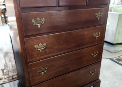 Classic wooden chest of drawers with brass handles in a traditional style.