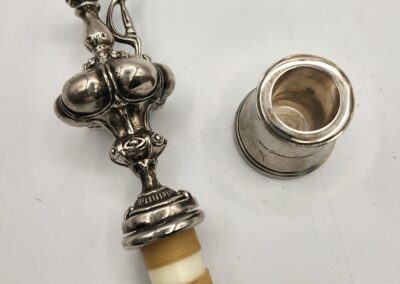 Vintage ornate silver perfume bottle with a stopper.