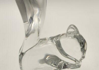 Clear glass sculpture of a squirrel with an upright tail.