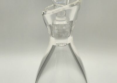 A clear glass decanter with a stopper on top.