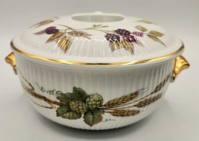 Decorative ceramic bowl with lid featuring botanical designs and gold accents.