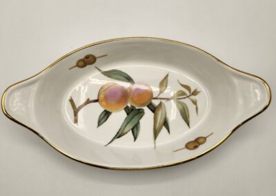 Elegant oval porcelain dish with peach design and gold accents.