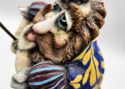 A whimsical, detailed figurine with exaggerated facial features and colorful attire.