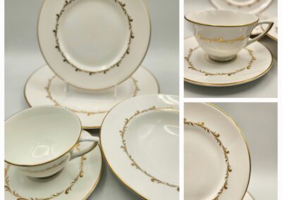 Elegant white china tea set with gold accents on plates and cups.