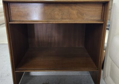 Vintage wooden cabinet with an open lower shelf and a top drawer.