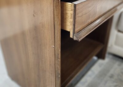Close-up of a wooden cabinet drawer slightly open.