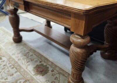 Elegant wooden table with carved legs and stretcher base.