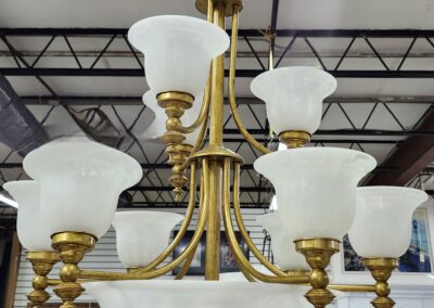 Elegant brass and white glass chandelier with multiple arms and shades.