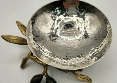 A unique metal bowl shaped like a turtle with a hammered texture.