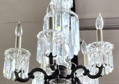 Elegant crystal chandelier with five candle-shaped bulbs and intricate glass detailing.