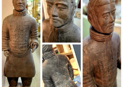 Ancient-style wooden statue with intricate carvings and detailed facial features.