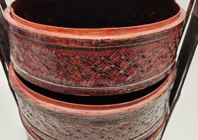 Stacked red and black textured containers with a handle.