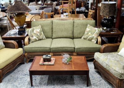Green cushioned sofa with patterned pillows in a cozy living room.