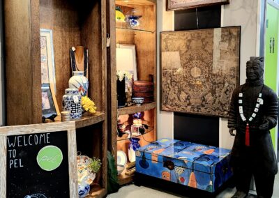 Eclectic room corner with a wooden cabinet, colorful bench, and a mannequin dressed in black.