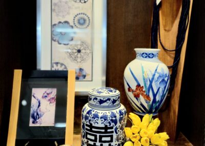 Decorative Asian-style vases and framed art with yellow flowers on display.