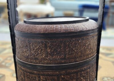 Intricately carved wooden tiered basket with handle.