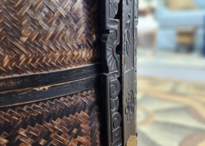 Close-up of a detailed wooden and woven basket corner.