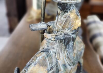 Intricate sculpture of a warrior on horseback with detailed attire and weaponry.