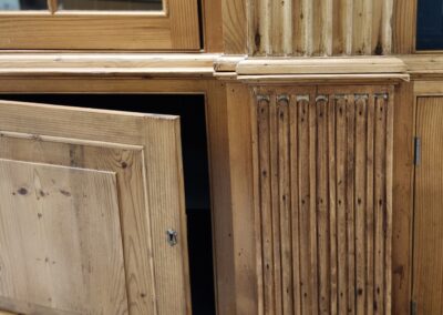 Close-up of a wooden cabinet door slightly ajar showing detailed carvings.