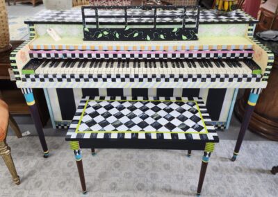 A piano and bench with bold black-and-white checkerboard patterns and colorful accents.