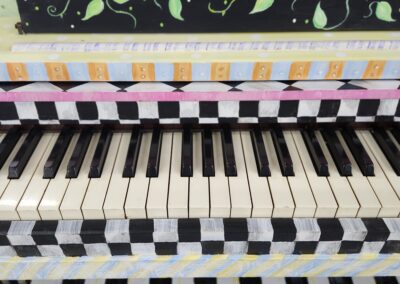 Artistic piano keys with black-and-white checkerboard patterns and green decorative swirls.