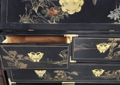 Antique black lacquer chest with intricate gold floral and butterfly designs.