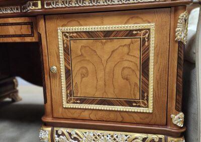 Ornate wooden desk drawer with intricate carvings and decorative metal accents.
