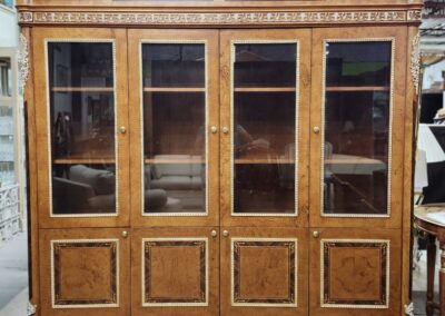 Vintage wooden glass-front cabinet with intricate carvings and multiple shelves.