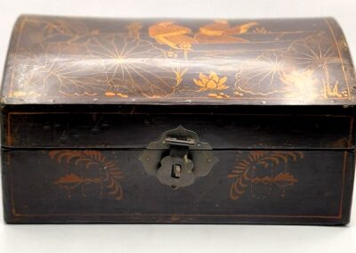 Antique wooden box with intricate floral carvings and a keyhole lock.