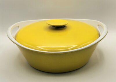 Bright yellow ceramic pot with lid on a white surface.