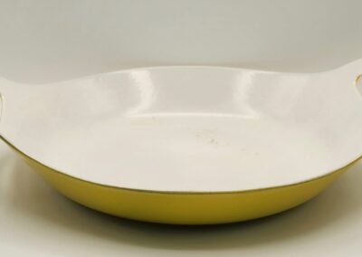 A shallow white bowl with a yellow exterior.