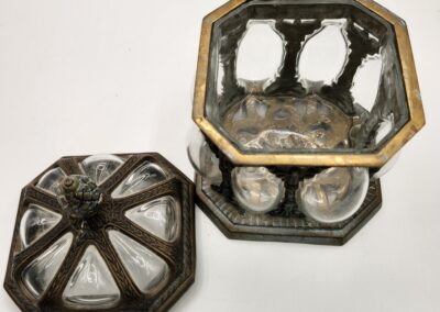 Antique octagonal silver container with intricate design and lid.