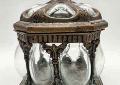 Ornate antique silver and glass container with a hexagonal base and intricate detailing.