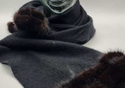 Elegant dark scarf with plush fur accents on a mannequin.
