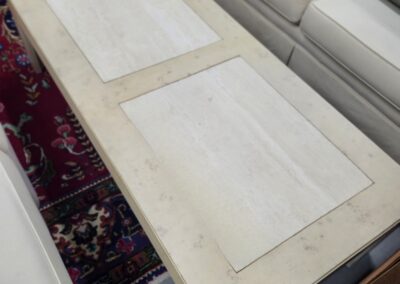A white coffee table with two papers on top in a living room.