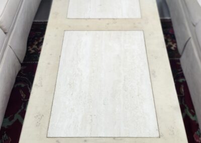 Rectangular coffee table with two white placemats between two sofas.