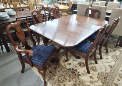 Elegant wooden dining table with blue upholstered chairs.