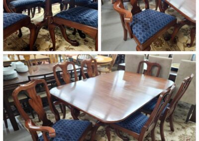 Elegant wooden dining table with matching upholstered chairs.