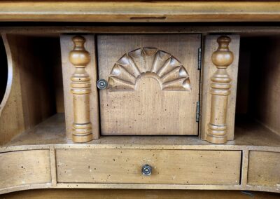 Carved wooden panel with decorative columns and fan motif.