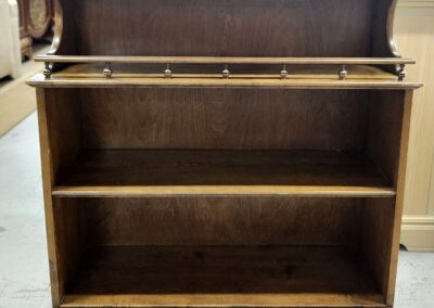 Wooden bookcase with two shelves and a fold-down writing surface.