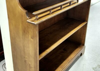Wooden bookshelf with two shelves and a small upper compartment.