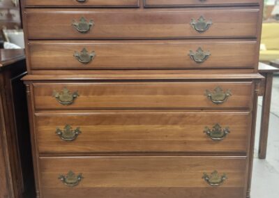 Vintage wooden chest of drawers with brass handles.