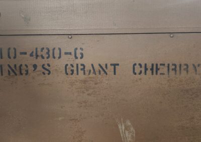 Close-up of text stenciled on a brown wooden surface.