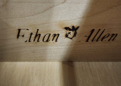 Wooden surface engraved with the name Ethan Allen.