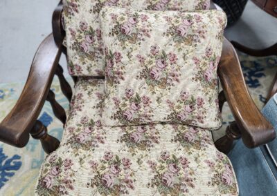 Floral cushioned wooden armchair with matching cushions.