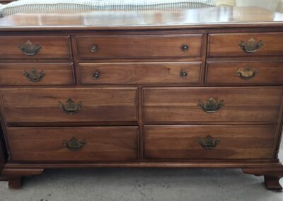 Classic wooden dresser with multiple drawers and brass handles.